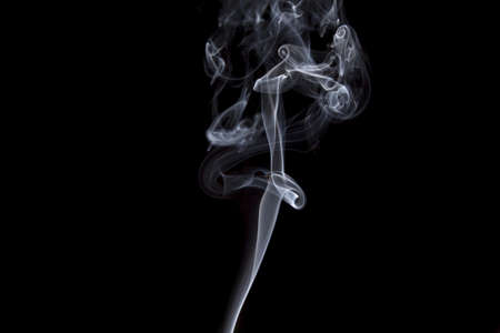 Smoke volutes on a pure black background の写真素材
