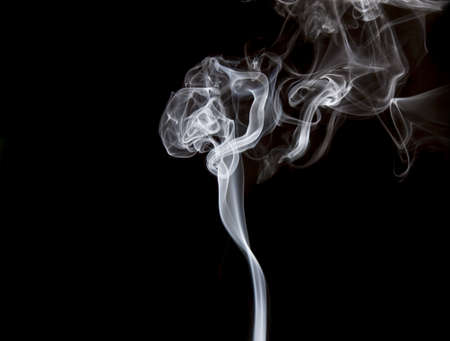Smoke volutes on a pure black background の写真素材