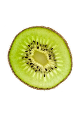 Retro-illuminated kiwi slice over a pure black backgroundの写真素材