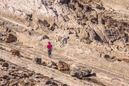 Mother and son exploring rocky coastの写真素材