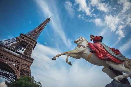 Eiffel Tower and the rider on the horse against the skyの写真素材