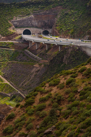 Highway in the mountains - cars entering the tunnel by the viaductの写真素材