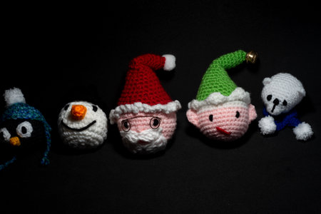 Portrait of Christmas Amigurumi crocheted or knitted stuffed toy on black backgroundの写真素材