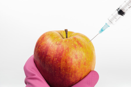 Genetically modified apple with syringeの写真素材