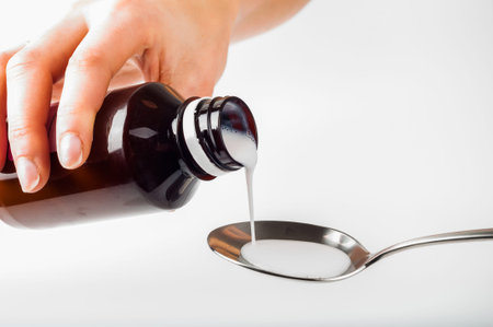 pour liquid medicine in metal spoon by handの写真素材