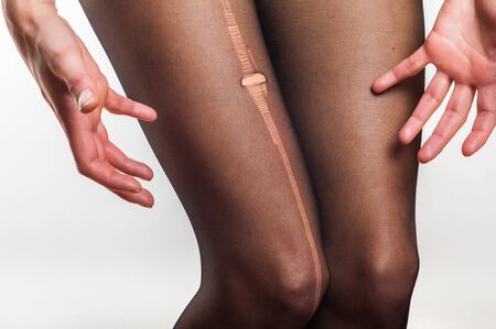 woman stressed about torn tightsの写真素材