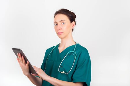 Portrait of young attractive doctor, surgeon, nurse with stethoscope and tabletの写真素材