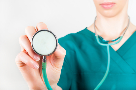 Medical doctor woman holding a stethoscope focus on the stethoscopeの写真素材