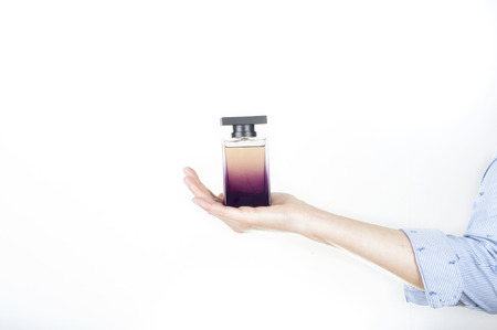 A female(woman) hand hold perfume container isolated whiteの写真素材
