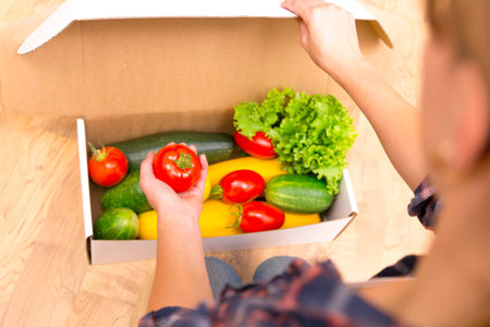 Box of fresh organic vegetables and fruits delivered to home - online grocery shopping service...