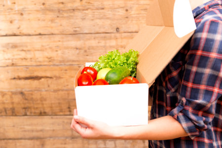 Box of fresh organic vegetables and fruits delivered to home - online grocery shopping service...