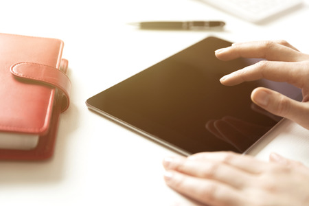 Business office items on white table, tablet and red notebook with penの写真素材