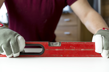 Carpenter's hands checking level of wooden table at home. DIY projects, handymanの写真素材