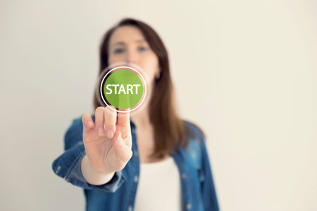 Young woman designer touching virtual button start. New start, beginning, business concept