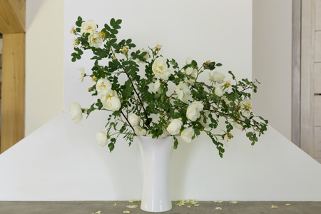 Bouquet of a white dogrose on a fireplace edge. Room decorの写真素材