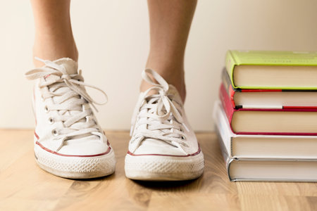 White sneakers and stack of books on the floor. Student, education and knowledge conceptの写真素材