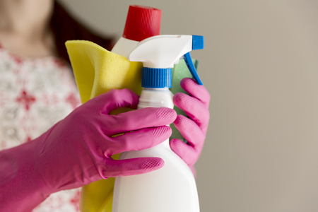 Young woman holding group of cleaning supplies. Household equipment, spring-cleaning, tidying up, cleaning service conceptの写真素材