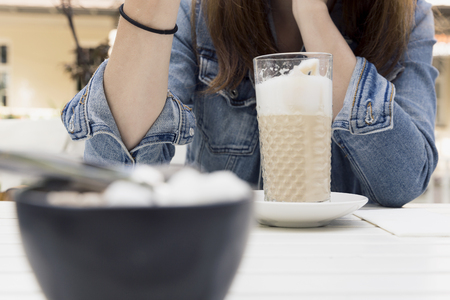 Young woman enjoying her latte at the coffee shop. Leisure, holiday, relaxingの写真素材