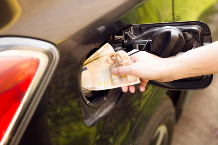 Transportation expenses concept - Euro money in car fuel tankの写真素材