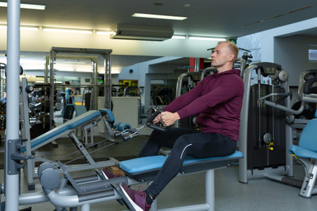 Man training in a gym. Fit young man in sportswear working out alone in a gym