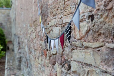 Outdoor building brick wall decorated with vintage fabric par flags. Festival, celebration conceptの写真素材