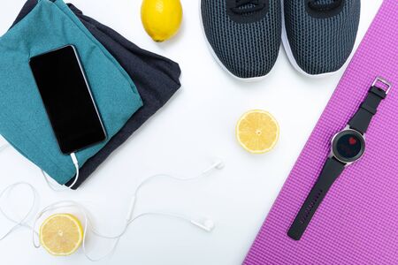 Flat lay with sportswear, fitness equipment and gadgets, smartphone and smartwatch. Fitness technologyの写真素材