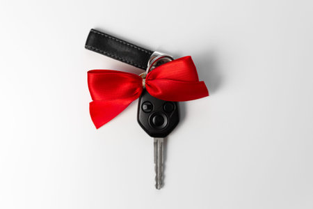 Car keys with red bow as present on white background. New car gift conceptの写真素材