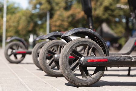 Electric urban transportation: the row of electric scooter bikes. Electric scooter rental in the city. Environmental transport in the cityの写真素材