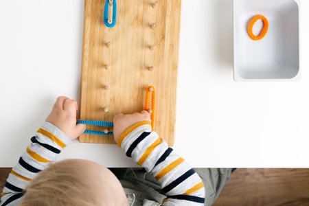 Child works with Montessori material for fine motor skills, sensory play. Playing childrenの写真素材