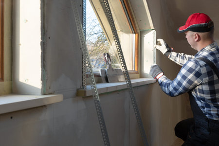 home improvement handyman installing window in new build attic by using leveler and laser leveler