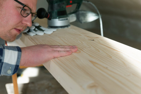 Carpentry. Wood sanding. Orbital sander for woodworking. In a natural light