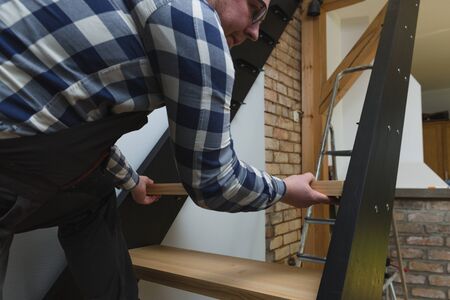 Home improvement handyman building staircase in a natural lightの写真素材