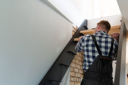 Home improvement handyman building staircase in a natural lightの写真素材
