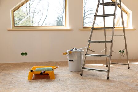 Home improvement. Painting tools roller, paint bucket and paintbrush in a natural light.の写真素材