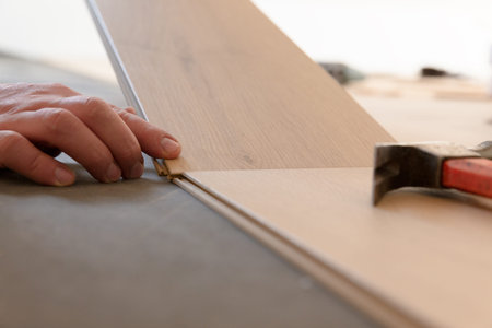 Construction worker installing laminate floor in a new renovated attic. Home improvement concept.