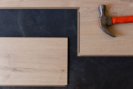 Construction worker installing laminate floor in a new renovated attic. Home improvement concept.の写真素材