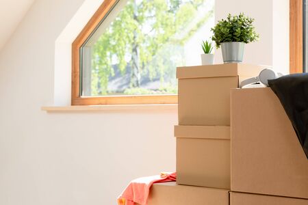 Move. Cardboard boxes for moving into a new, clean home. In a sunny day by a window in attic.の写真素材