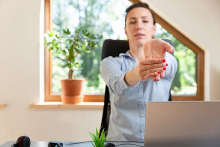Beautiful women performing exercises and stretching in front of a laptop. Working at home, health concept.の写真素材