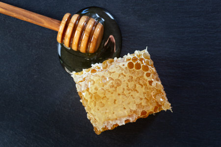 organic honey and rustic bread on a dark stone background. Healthy eating breakfast.
