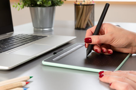 Beautiful graphic designer drawing digital design on a drawing tablet