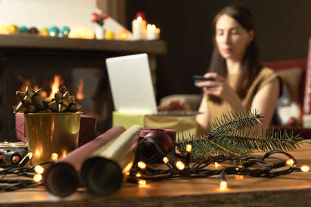 Gift workshop in a warm cozy room. Christmas decorations by fireplace. Ordering gifts onlineの写真素材