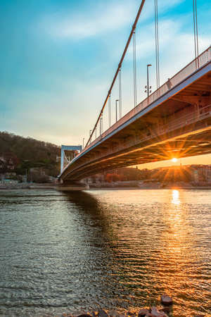 Hungary Budapest, Erzsebet bridge at sunset, sun rays are reflected on the waterの写真素材