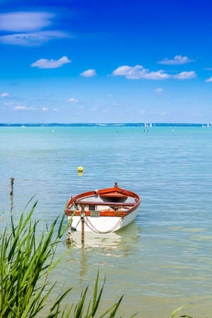 Fishing boats are moored to the shore of a lake with turquoise water.の写真素材