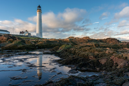 Lighthouse on the coast of the North Sea in Scotland against a dramatic skyの写真素材