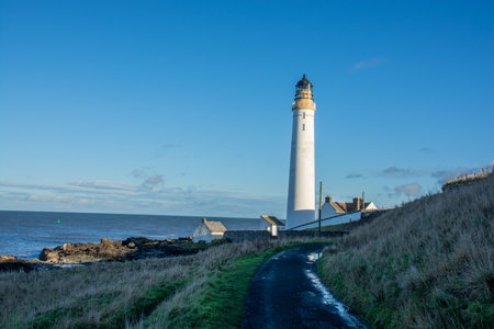 Lighthouse on the coast of the North Sea in Scotland against a dramatic skyの写真素材