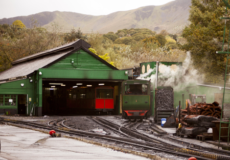 Retro steam train departs from the railway station.の写真素材