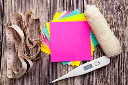 Yellow and blue sticky note with empty space for a text on wooden background. Health concept...