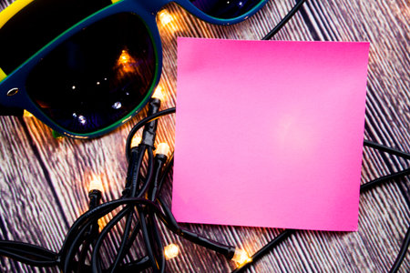 Place for writing sticky note pinned on the wooden background and lights