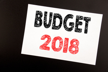 Hand writing text caption inspiration showing Budget 2018. Business concept for Household budgeting accounting planning written on sticky note, black background copy spaceの写真素材