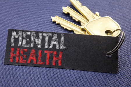 Handwritten text showing Mental Health. Business concept writing for Anxiety Illness Disorder Written on note paper attached to key, black background with space close upの写真素材